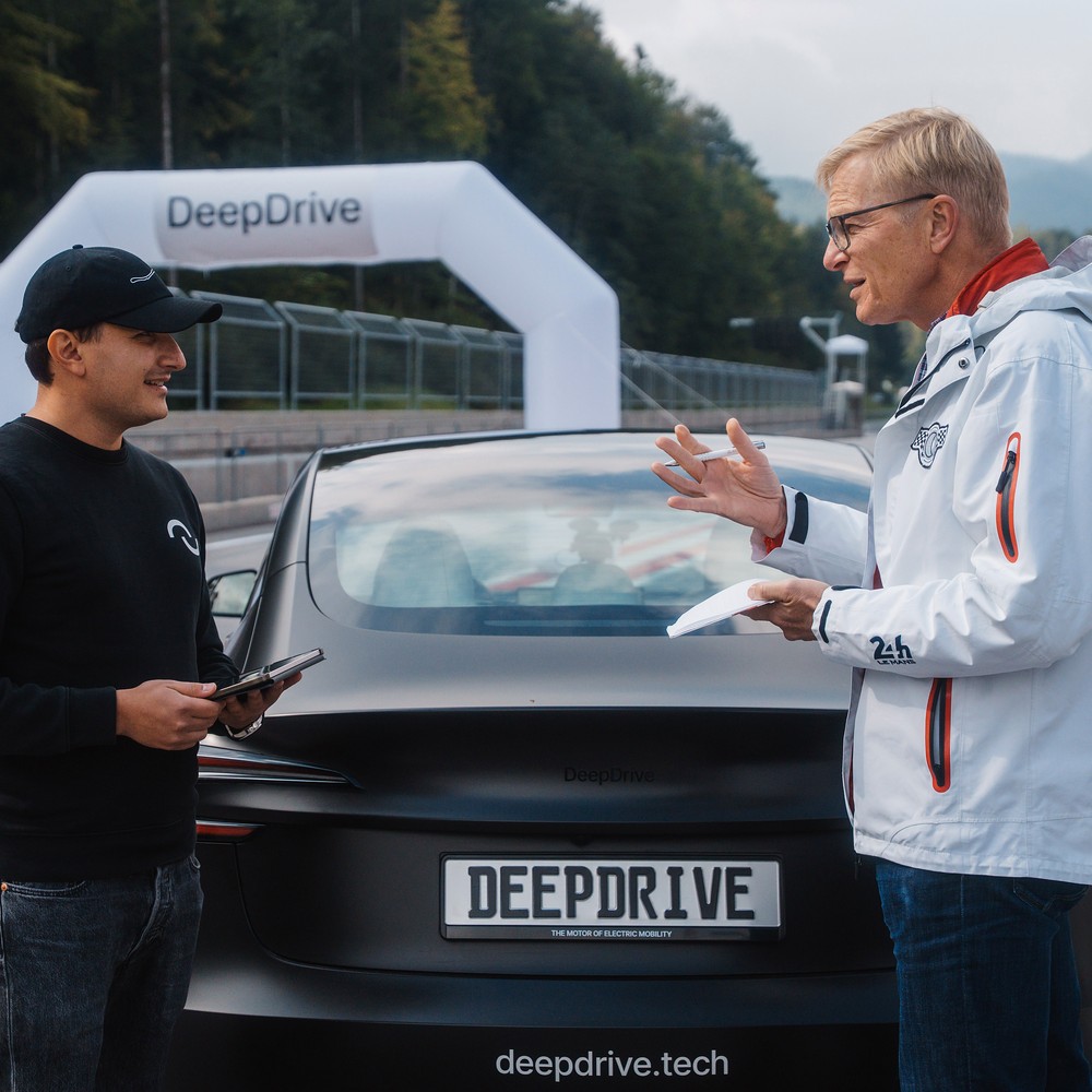 Christian Bangemann im Gespräch an einem Elektrofahrzeug